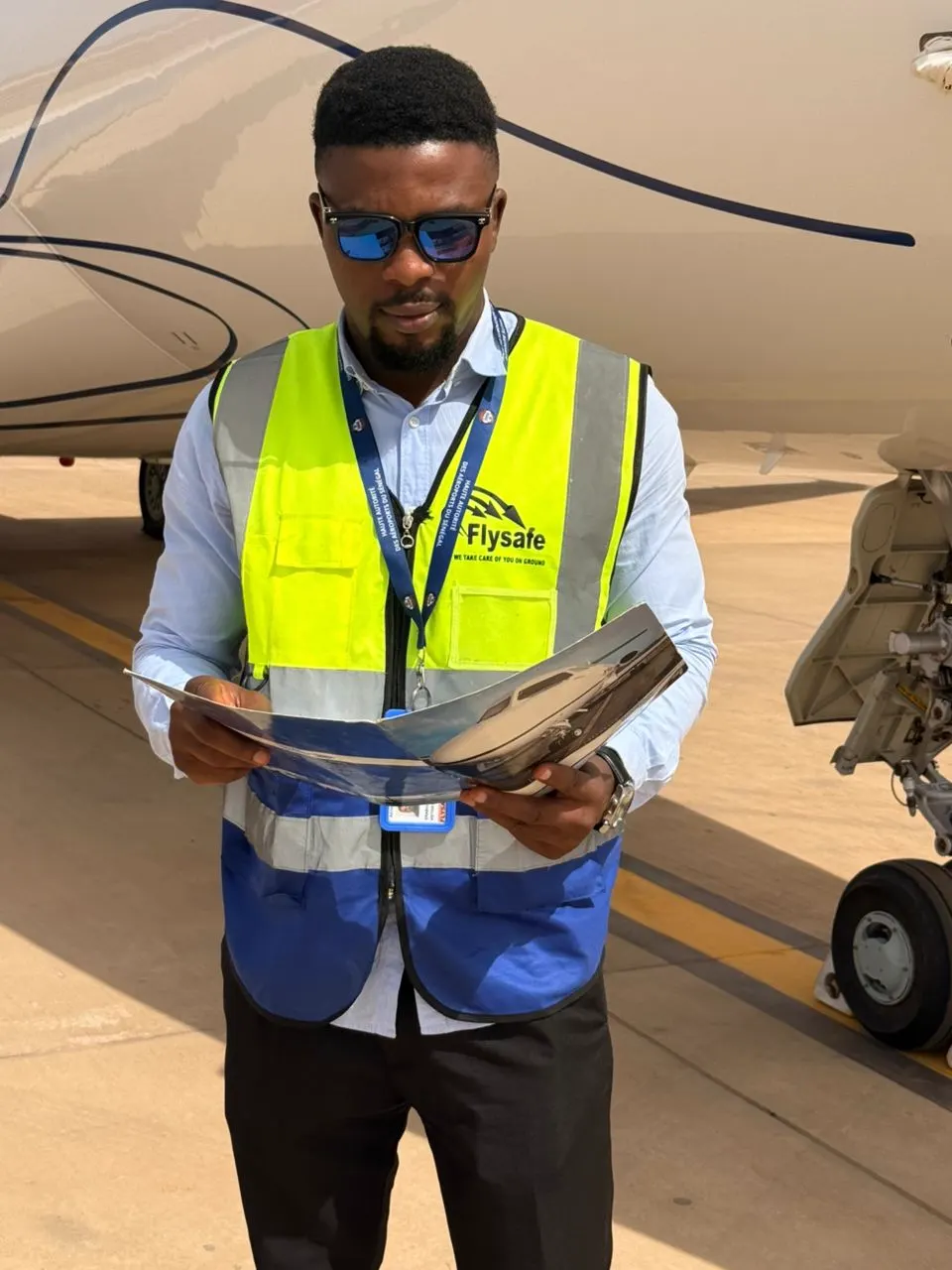 Flysafe ramp personnel reviewing handling paperwork beside an aircraft